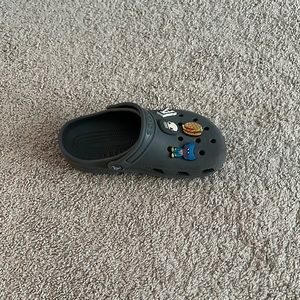 A pair of crocs color grey size 4